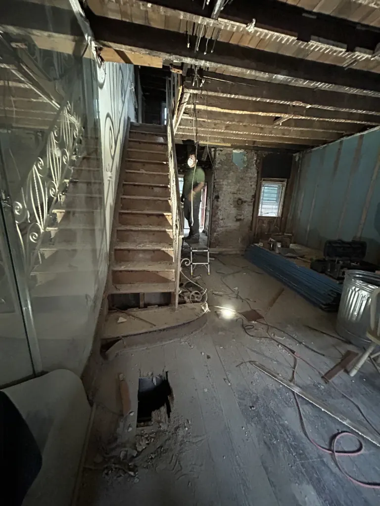 The original staircase and open ground floor during early demolition.