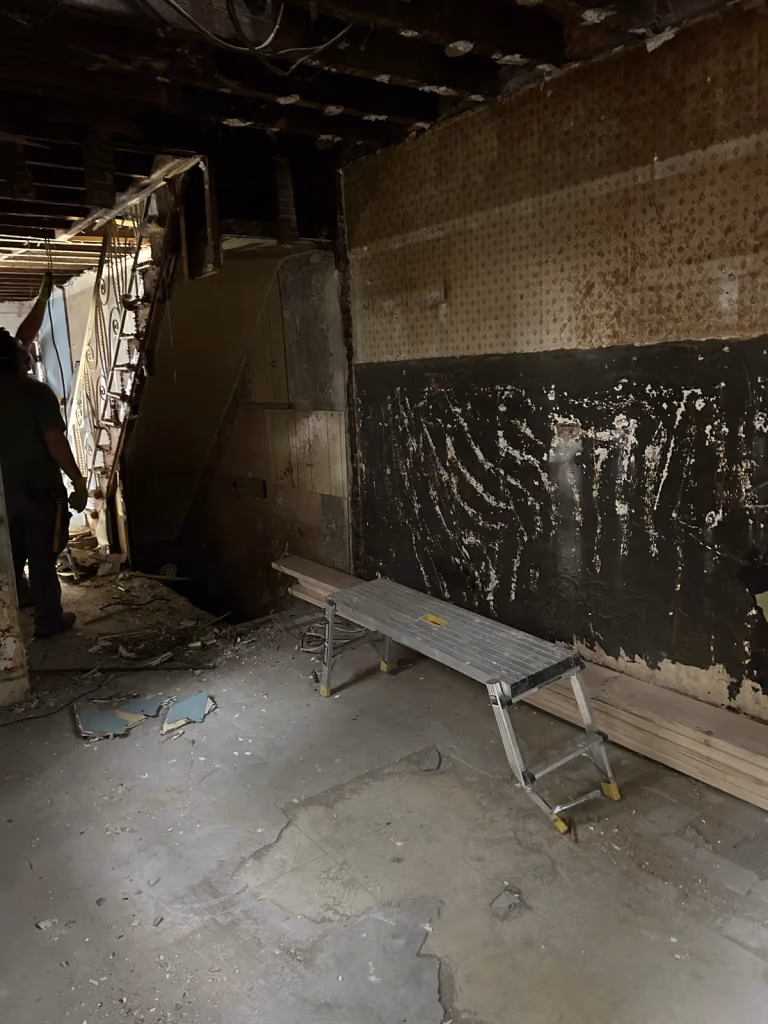 The original rear rooms with exposed walls and ceiling joists.
