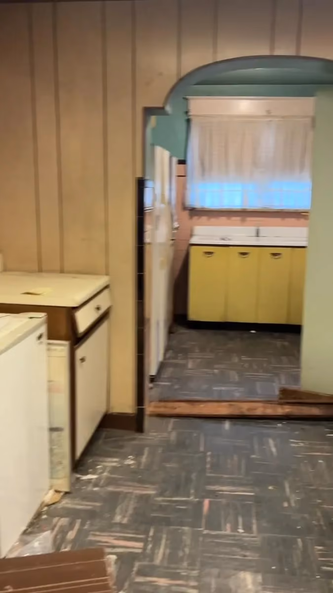 The original kitchen viewed through the doorway and paneled room.