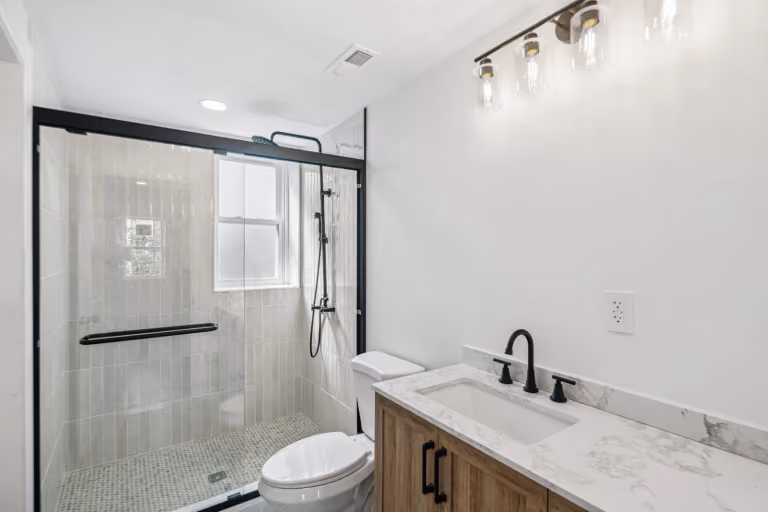 The glass shower and wood-tone vanity