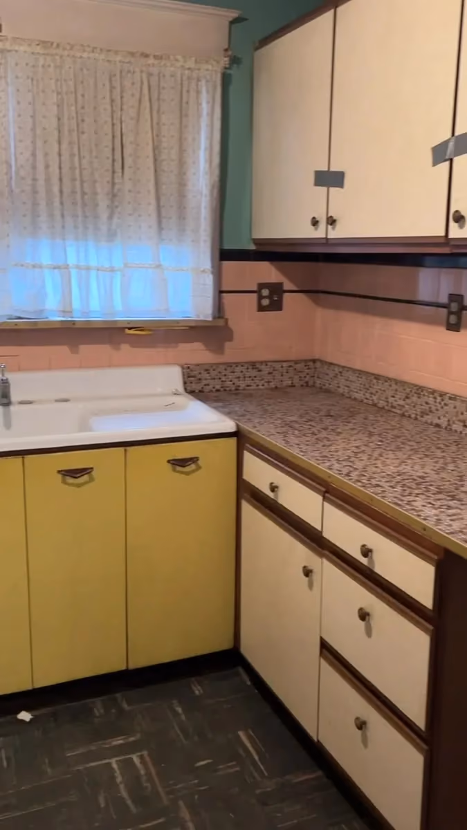 The original kitchen, with yellow cabinet doors and patterned worktops.